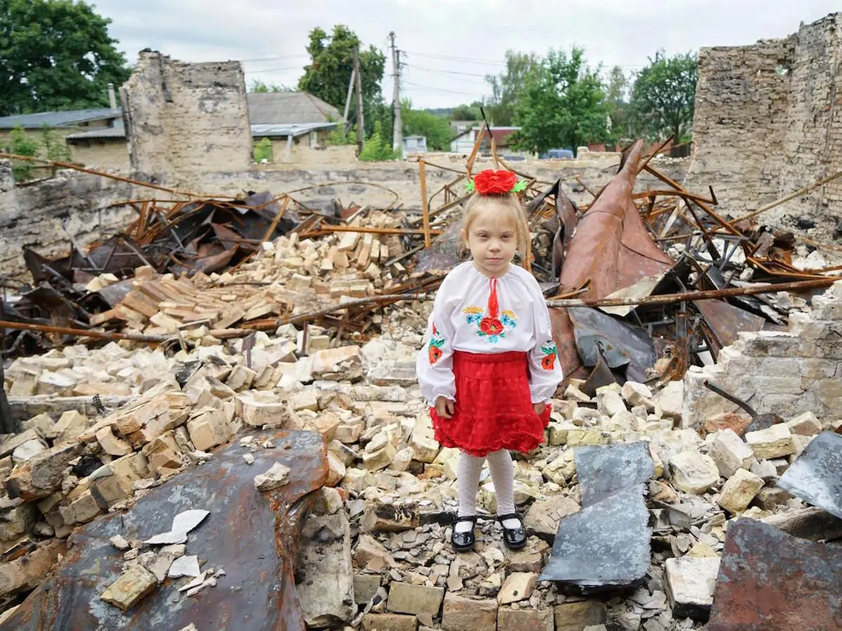 Ukrainian girl standing in war ruins